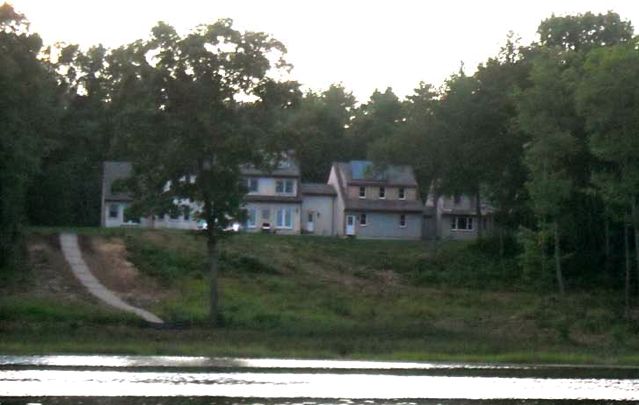 Picture of poor buffer and eroding slope between shoreline and housing.